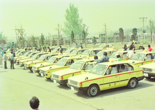 Deluxe taxi standing by at district office for filial tour to Haengjusanseong Fortress (1991)